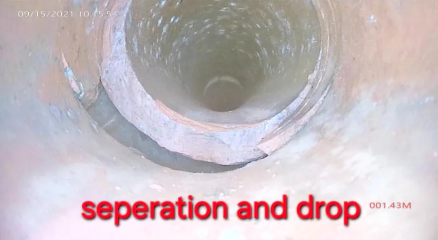 A separated pipe joint with a downstream drop visible from the sewer camera
